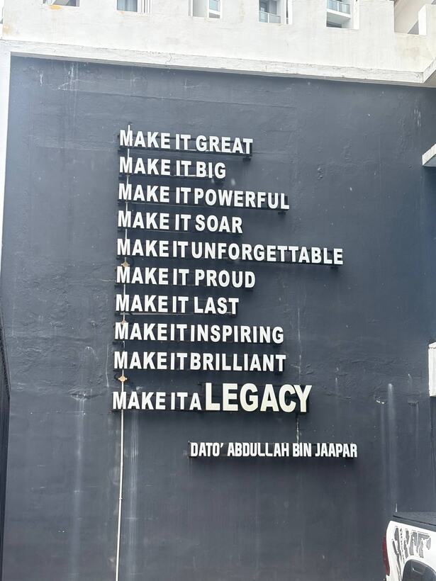 A dark wall painted with a list in white capitals, from make it great to make it a legacy