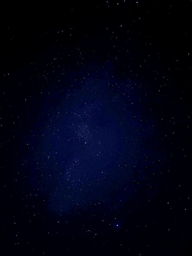 A dense star field with the faint band of the Milky Way across it